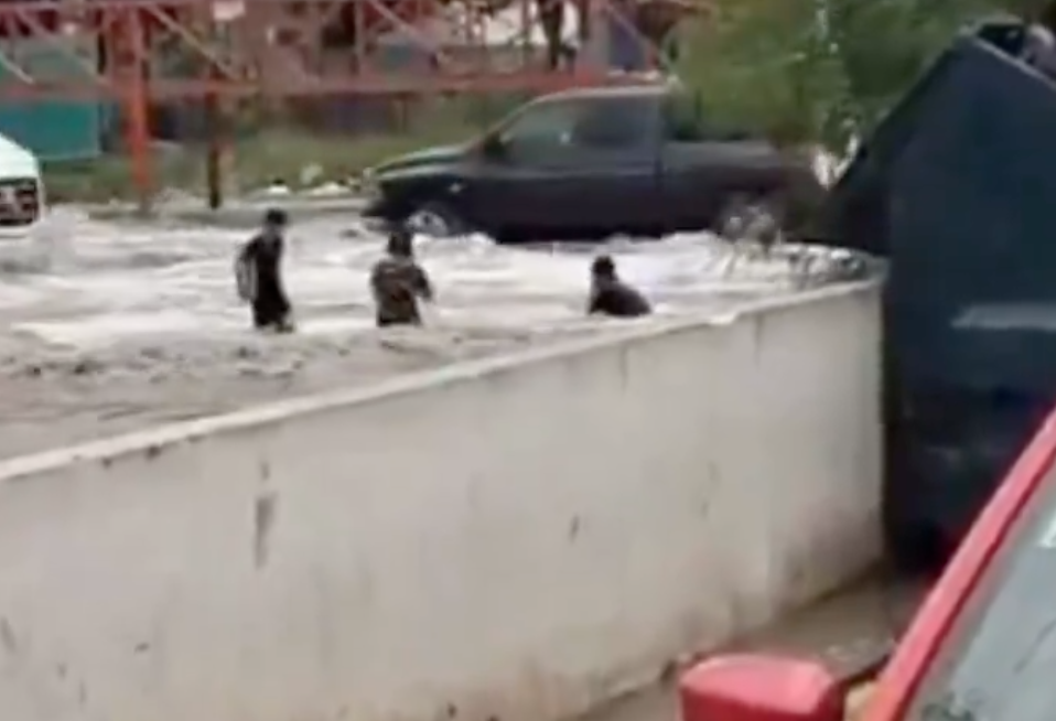Niños nadan en calle inundada tras fuertes lluvias en Nuevo León